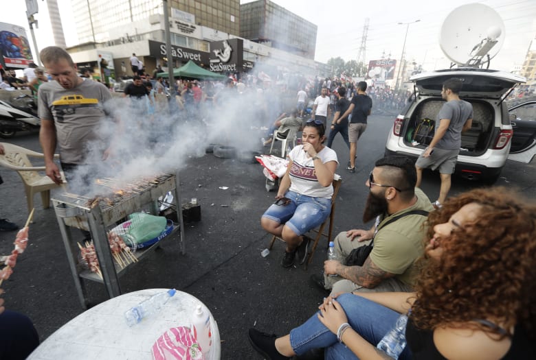 متظاهر لبناني يشوي اللحم على طريق سريع يربط بيروت بشمال لبنان، في زوق مصبح