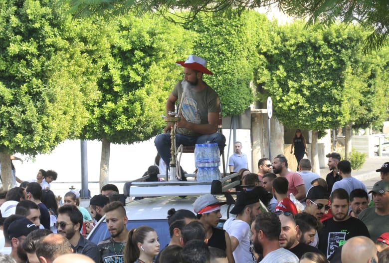 شاب يدخن النرجيلة في صيدا أثناء الاحتجاجات التي تشهدها البلاد